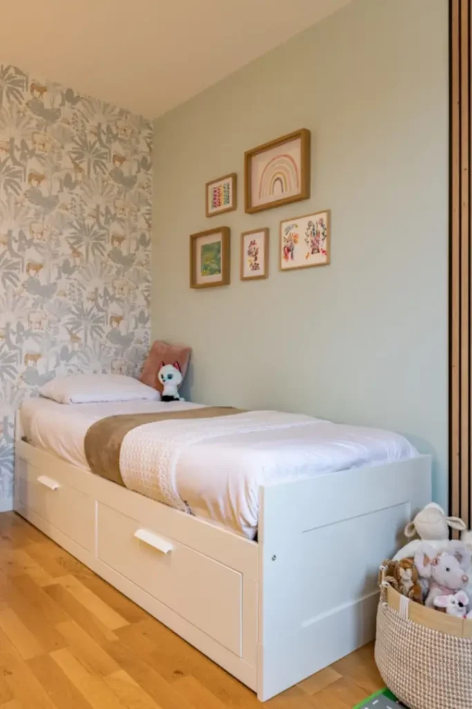 Chambre d'enfant réaménagée avec un lit contenant Des espaces de rangement